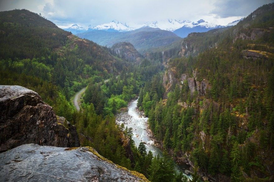 View overlooking the spectacular Cheakamus Canyon. The curving railroad tracks show the route of the Rocky Mountaineer train. Tantalus mountains in the distance.
